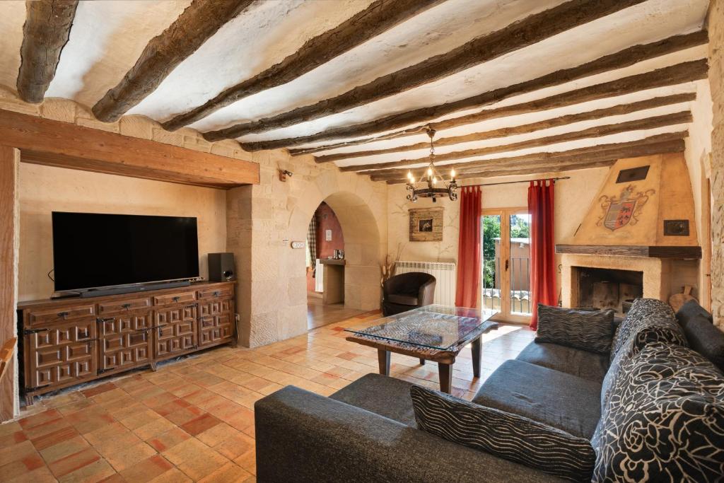 a living room with a couch and a tv at Atalaya in Santa Eulalia la Mayor