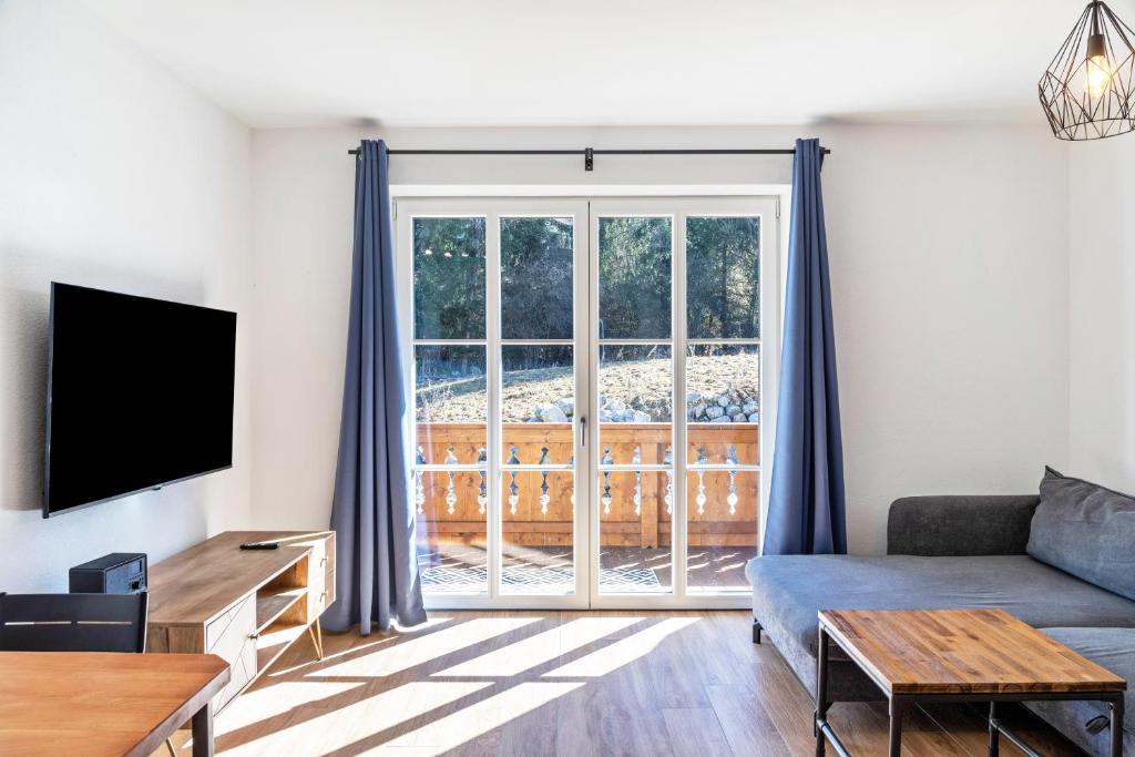 a living room with a couch and a sliding glass door at Beim Klarwein in Farchant