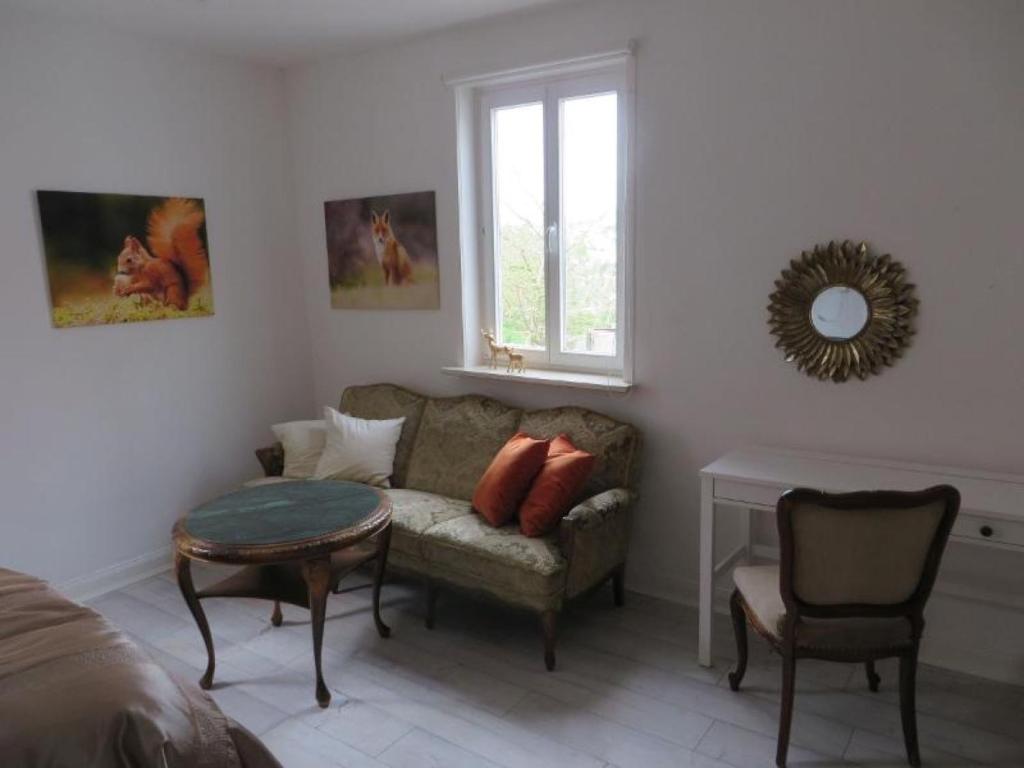 a living room with a couch and a table at Ferienwohnung Pfieffetalblick in Spangenberg