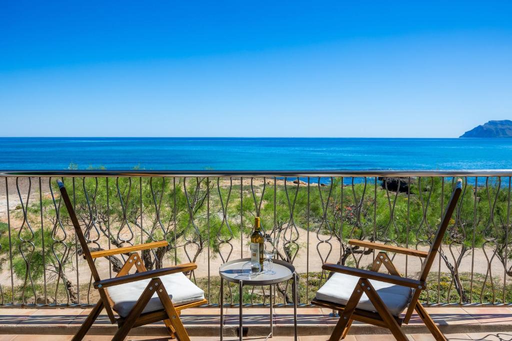 two chairs and a table on a balcony with the beach at Ran de Mar in Son Serra de Marina