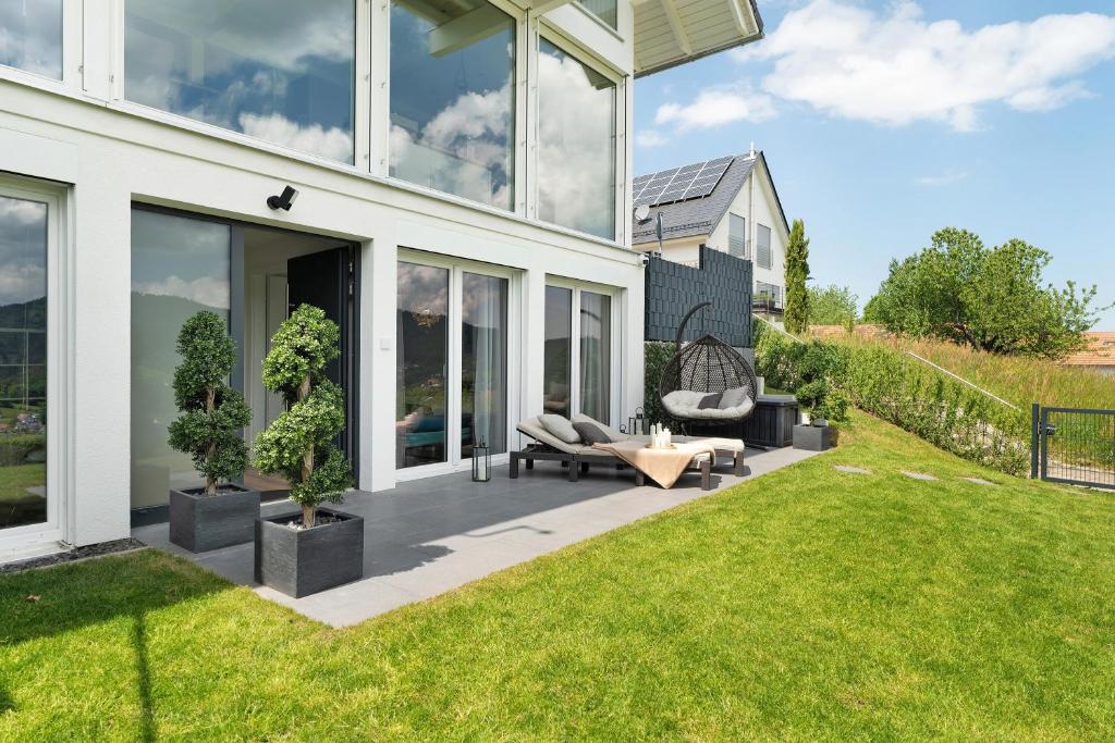 a patio with a couch and chairs on a lawn at Ferienwohnung Luftige Auszeit in Bühlertal