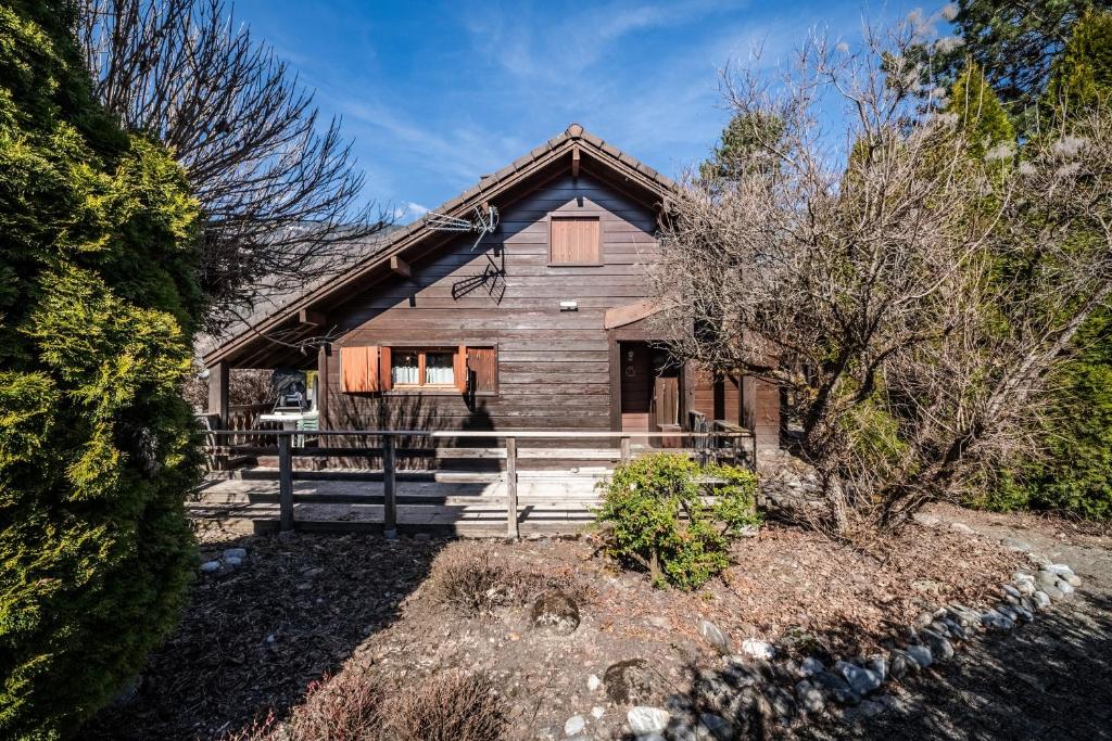 a large wooden house with a fence in front of it at Chalet 6p Confort - Le bouvreuil in Verchaix