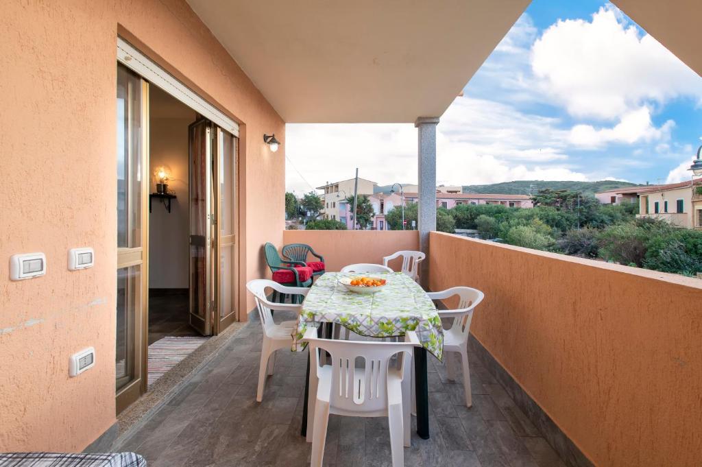 a patio with a table and chairs on a balcony at Veranda Vista Mare Isola Rossa in Isola Rossa
