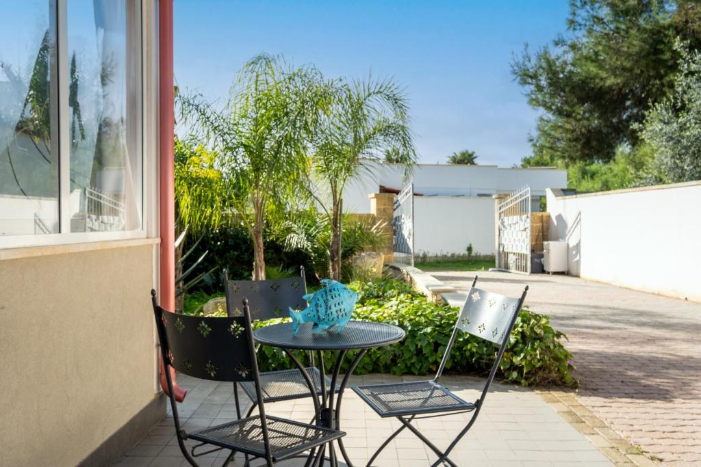 a table and two chairs on a patio at Elenya Garden Retreat in Torre Lapillo