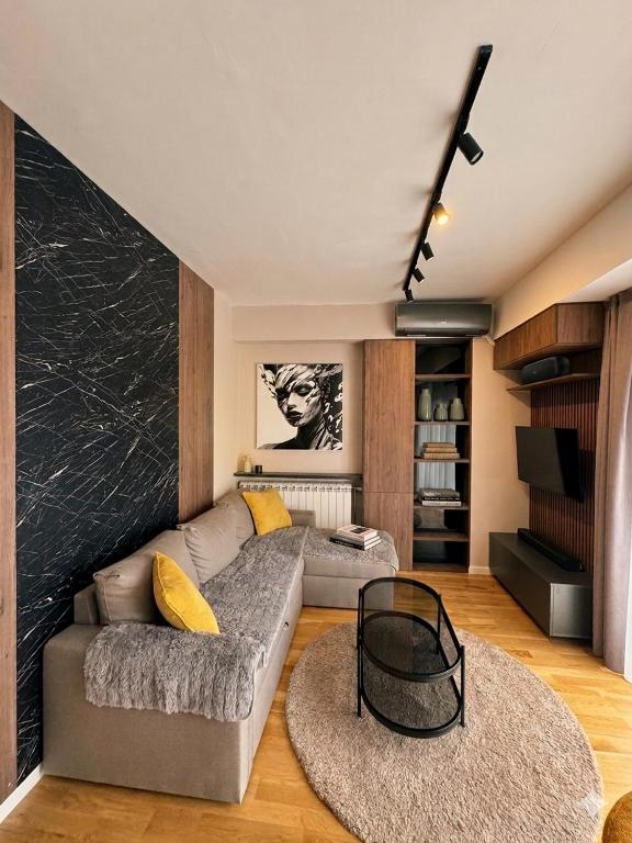 a living room with a couch and two rugs at Emerald Luxury Apartments in Skopje