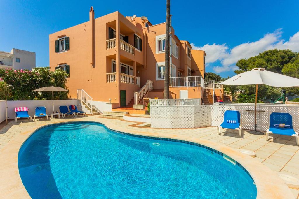 a villa with a swimming pool in front of a house at Villa Lidia in Cala Galdana