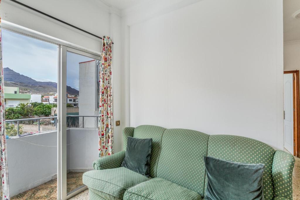 a living room with a green couch and a balcony at Apartamento karla in San Nicolás