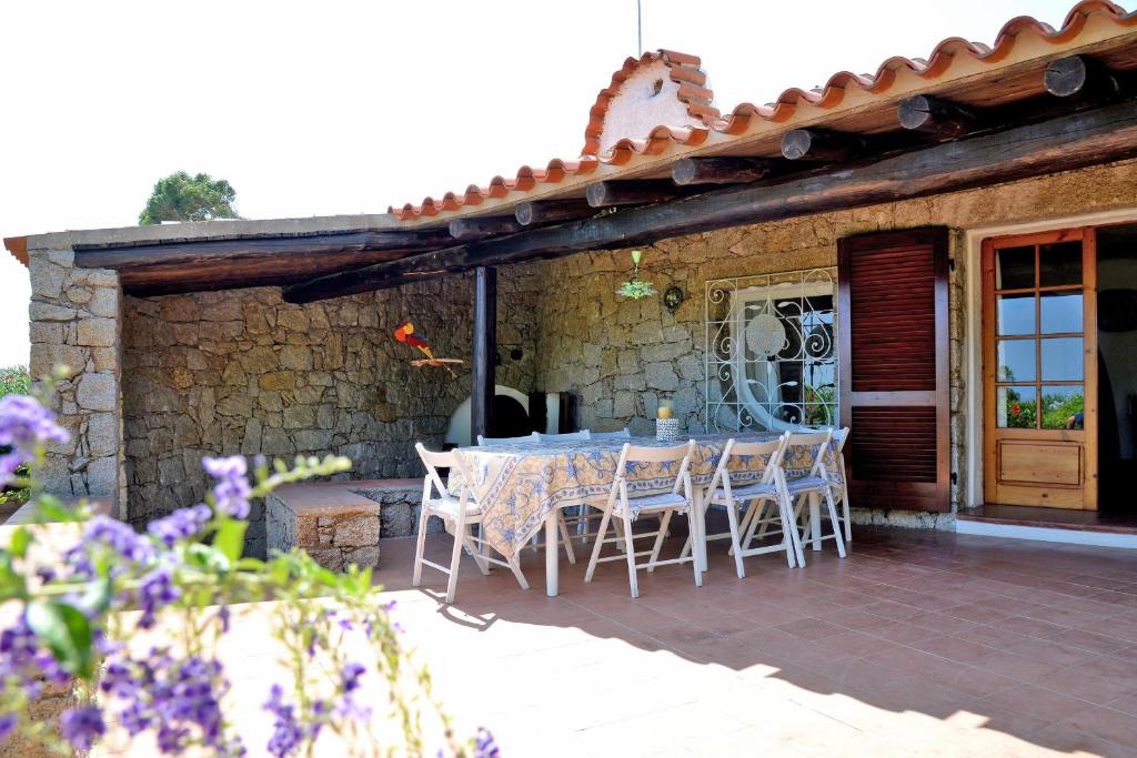 a patio with a table and chairs on a house at Villa Ibiscus in Porto Rafael