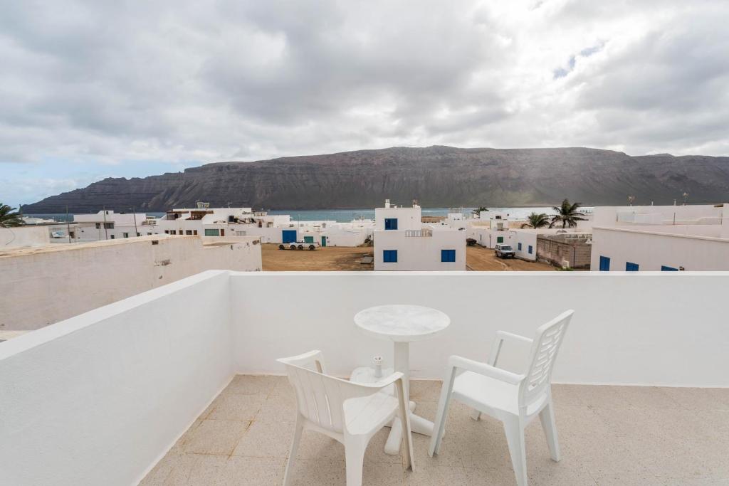 a table and chairs on a balcony with a view at El Sombrerito 6 in Caleta de Sebo