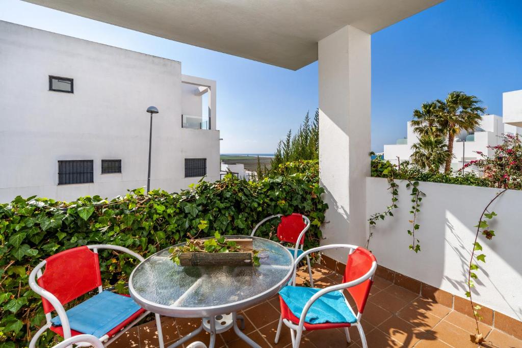 a patio with a table and chairs on a balcony at Casa Frank in Conil de la Frontera
