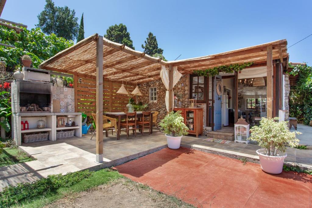 a backyard with a wooden pergola and a kitchen at Finca la Florida in Icod de los Vinos