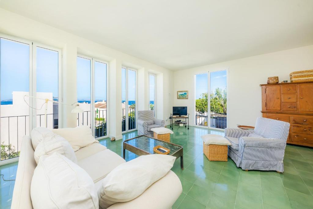a living room with white furniture and windows at Villa Mercedes in Artá