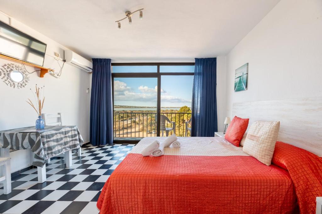a bedroom with a bed and a view of the ocean at Estudio Mirada 304 in Es Pujols