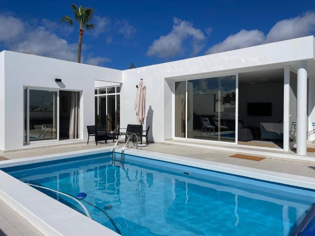 a swimming pool in front of a house at Casa Guayo in Tías
