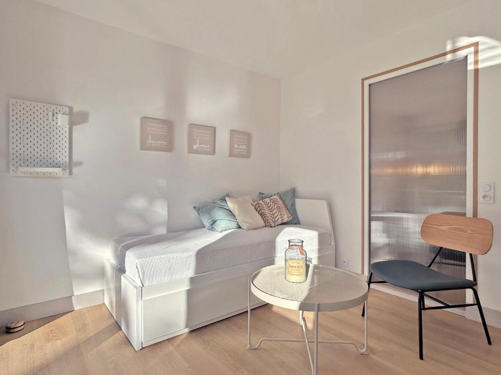 a small bedroom with a bed and a table at Au p'tit Colombier in Hillion