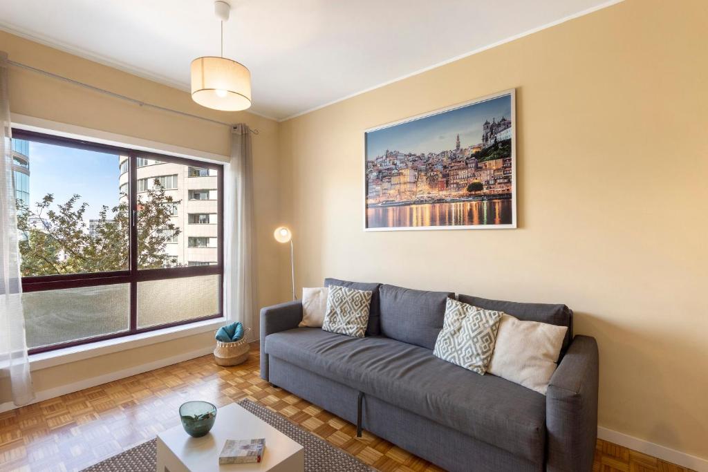 a living room with a couch and a large window at Destiny Oporto in Maia