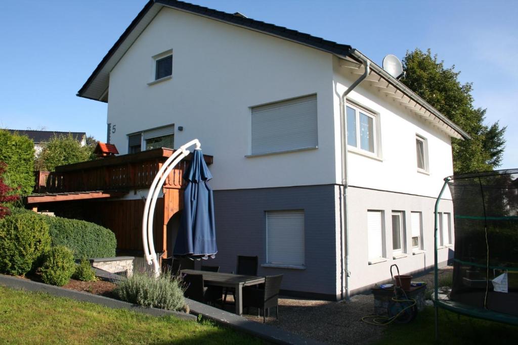 a white house with an umbrella in the yard at Ferienwohnung Sammet in Brilon