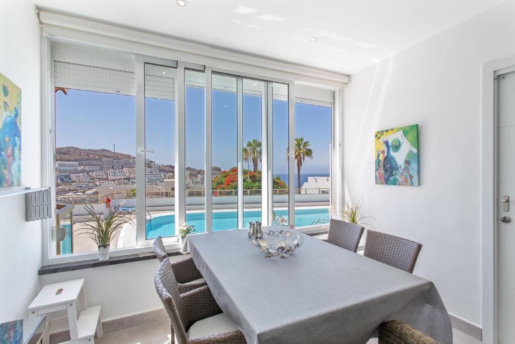 a dining room with a table and views of the ocean at Brisas Canarias in Puerto Rico de Gran Canaria