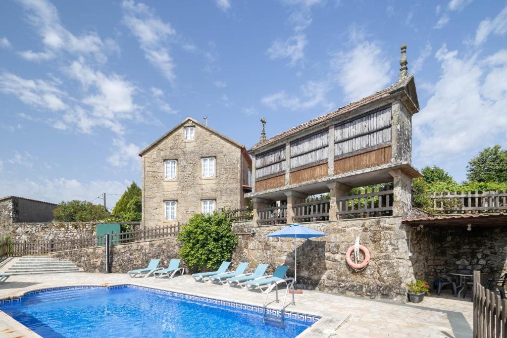 a house with a swimming pool in front of a building at Casa De Marica in A Estrada
