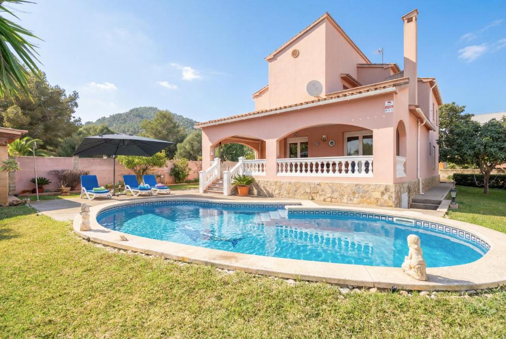 a villa with a swimming pool in front of a house at Villa Epi in Cala Ratjada