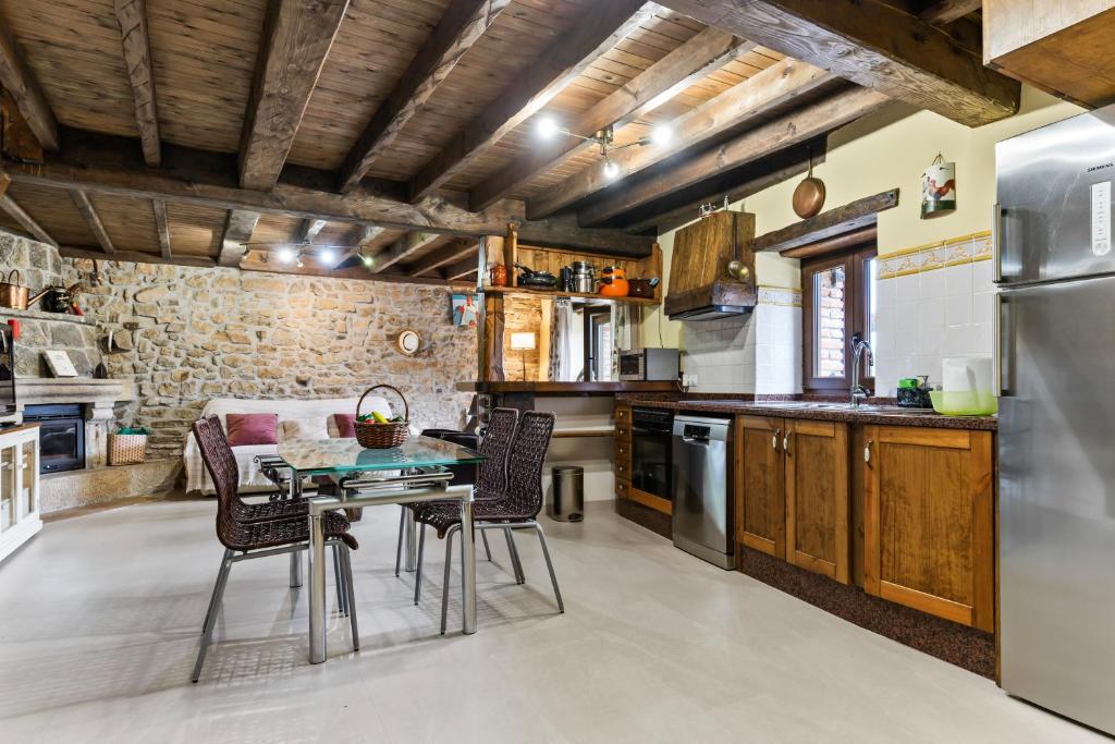 a kitchen with a table and chairs and a refrigerator at Casa Rural Adrimar in Selorio