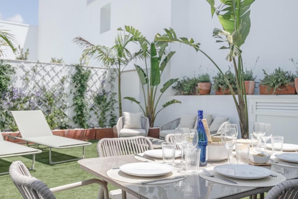 a table with plates and glasses on a patio at La Casa de Emilie- Solo Familias in Conil de la Frontera