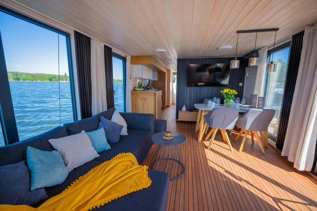 a living room with a blue couch and a kitchen at Magisches Abenteuer-Hausboot Juno in Fürstenberg