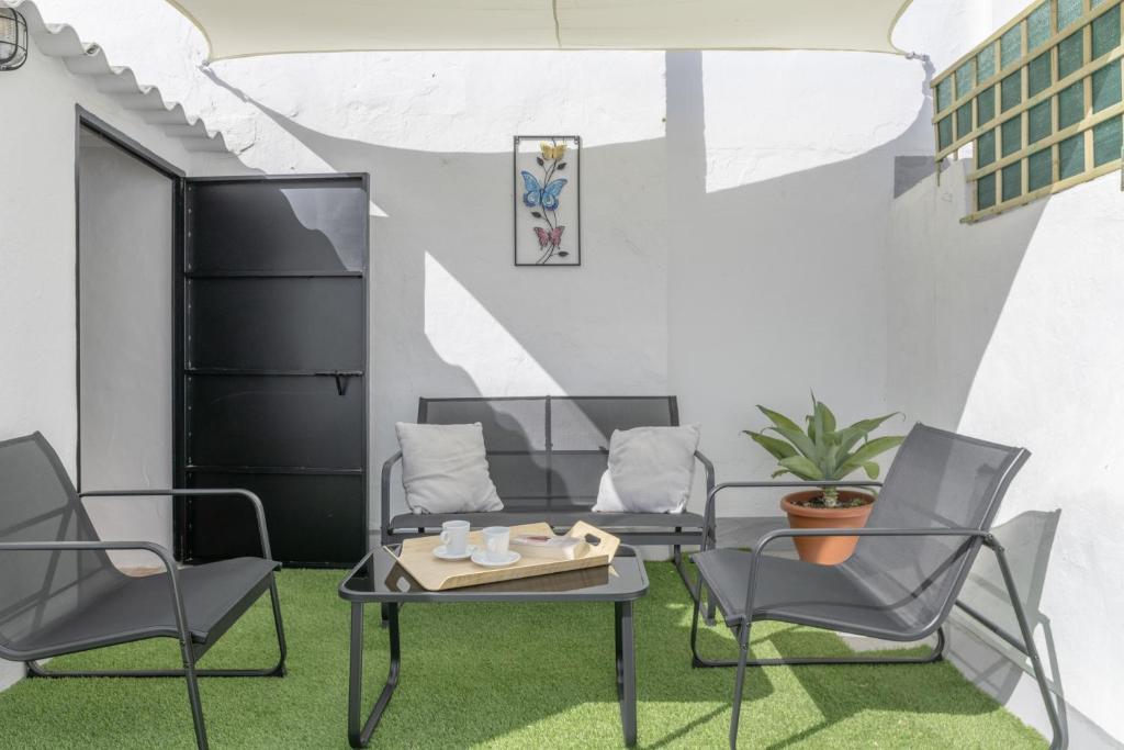 a patio with chairs and a table with a tray on it at El Rincón de Hugo in Alcalá de los Gazules