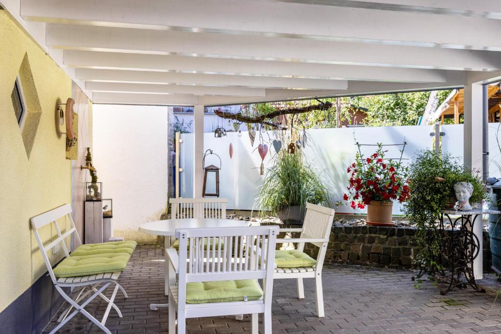 a patio with a table and chairs under a white umbrella at Die Schneiderei in Balingen