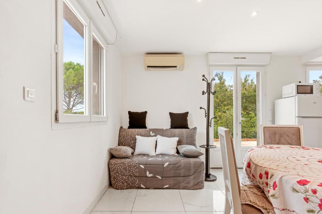 a living room with a chair and a bed at Charmant appartement avec terrasse in Brignoles