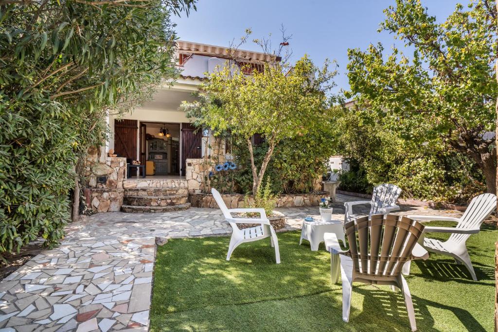 a patio with chairs and a table in a yard at Al mare da Pépé in Budoni