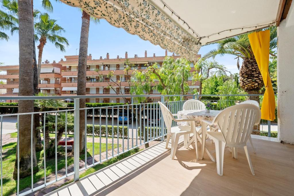 a balcony with tables and chairs and a view of a building at beach and pool in Cambrils