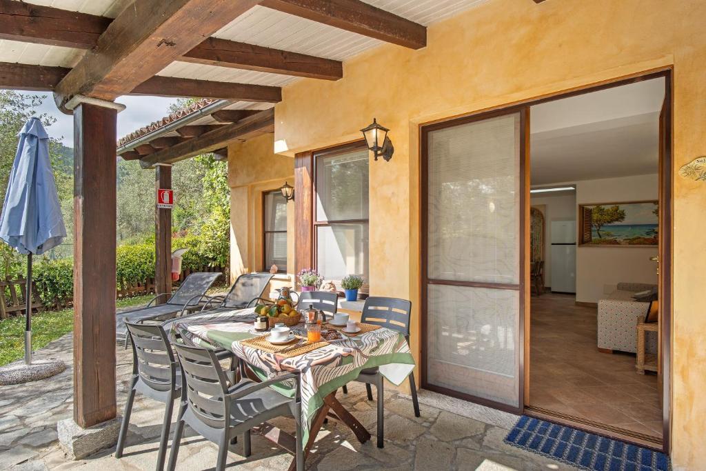 a patio with a table and chairs on a patio at Il Giardino del Sole, Chalet Salvia in Garlenda