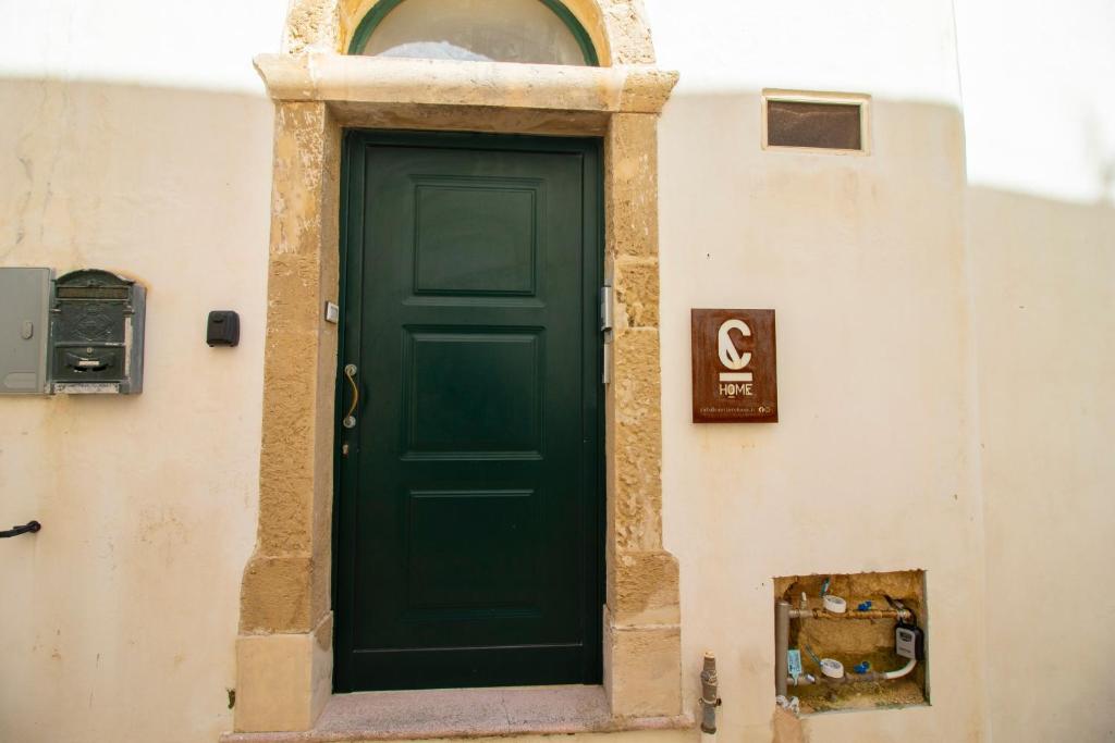 a green door on the side of a building at C-Home Historic House in Otranto