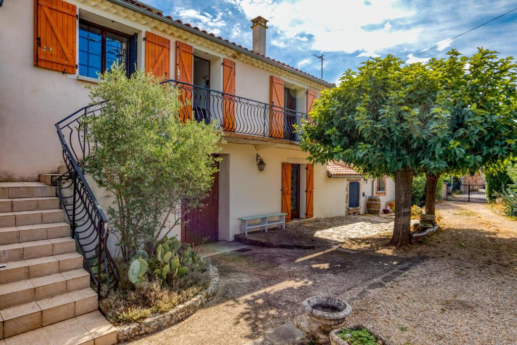 an old house with a staircase and a tree at La Trêve in La Tour-sur-Orb