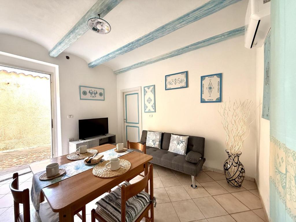 a living room with a table and a couch at Essenedda Holiday Home in Orosei