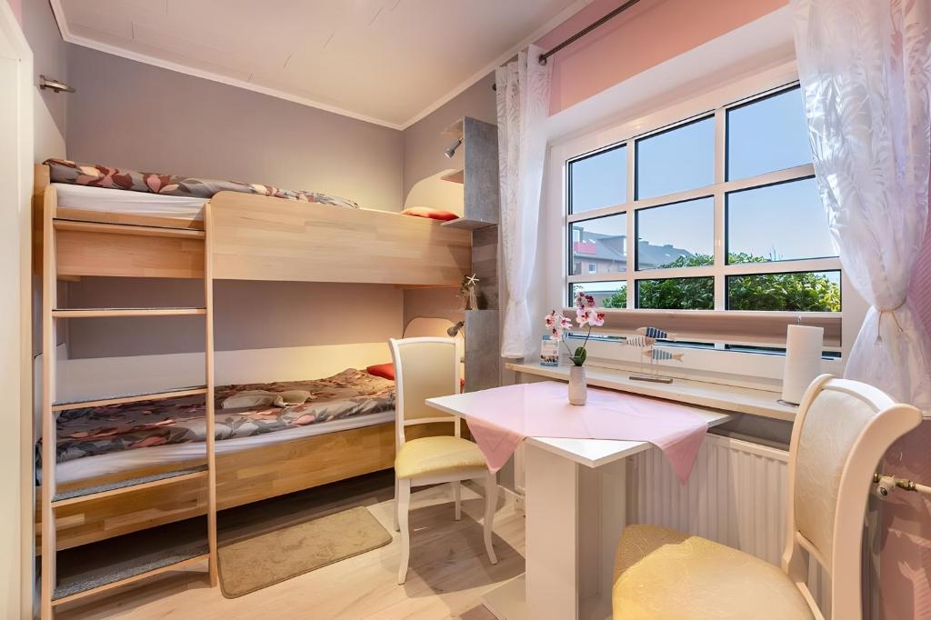 a room with bunk beds and a table at Ferienwohnung Wencke in Büsum