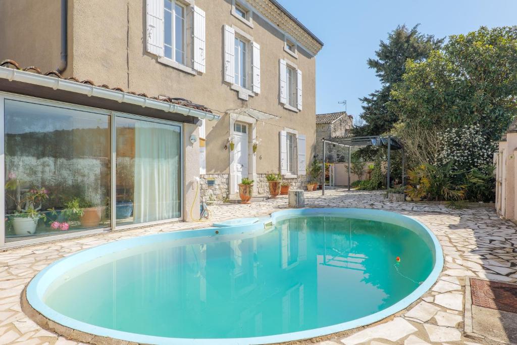 a swimming pool in the yard of a house at Gîte Le Chant Des Oiseaux in Pradons