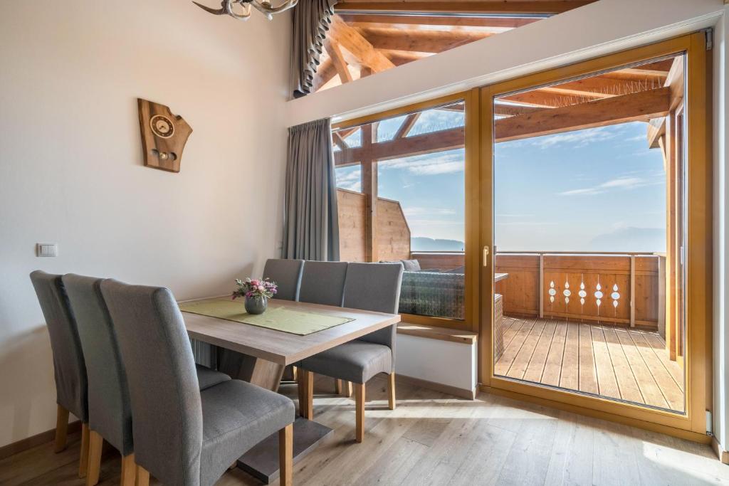 a dining room with a table and chairs and a balcony at Eggerhof Familiennestl in Verano