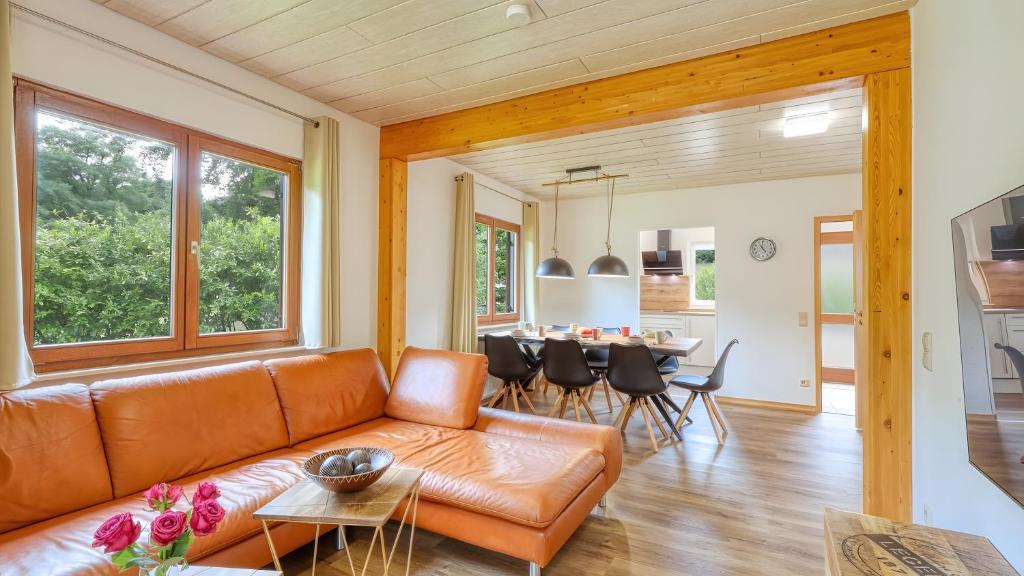 a living room with a couch and a table at Waldblick - Stilvolles Ferienhaus in Kemmerode