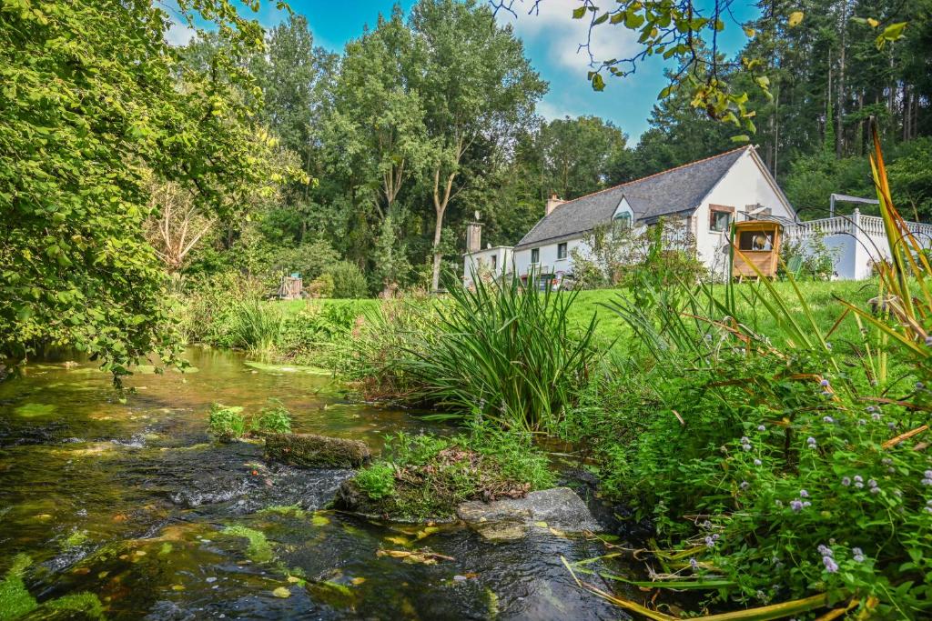 a house with a stream in front of it at L'Annexe du Petit Echo de la mode in Plélo