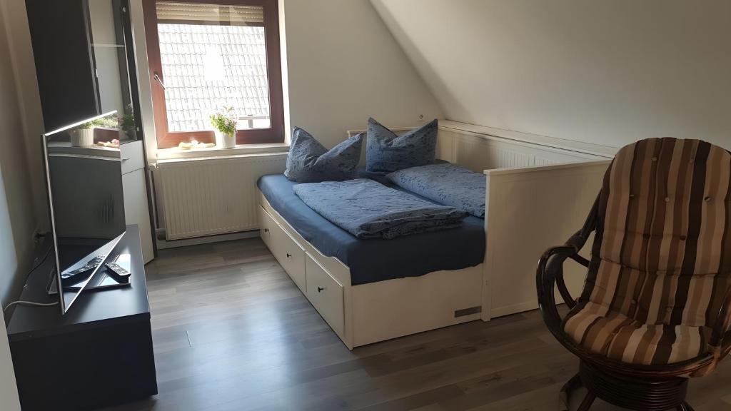 a bedroom with a bed with blue pillows and a chair at Fewo Drei Gleichen Nr 1 in Wandersleben