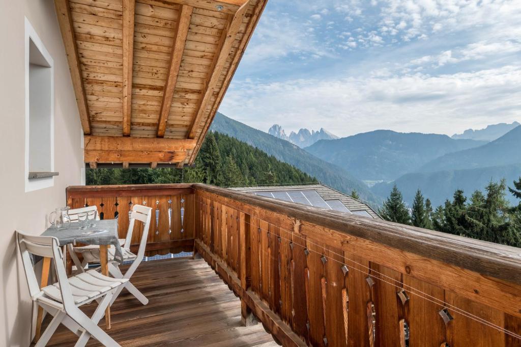 a balcony with a table and chairs and mountains at Funtnatsch Apartment Langkofel in Laion