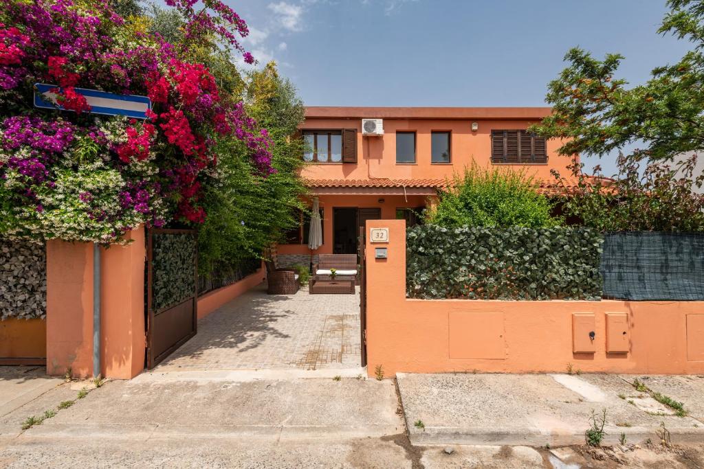an orange house with flowers on a fence at Tara house in Pula
