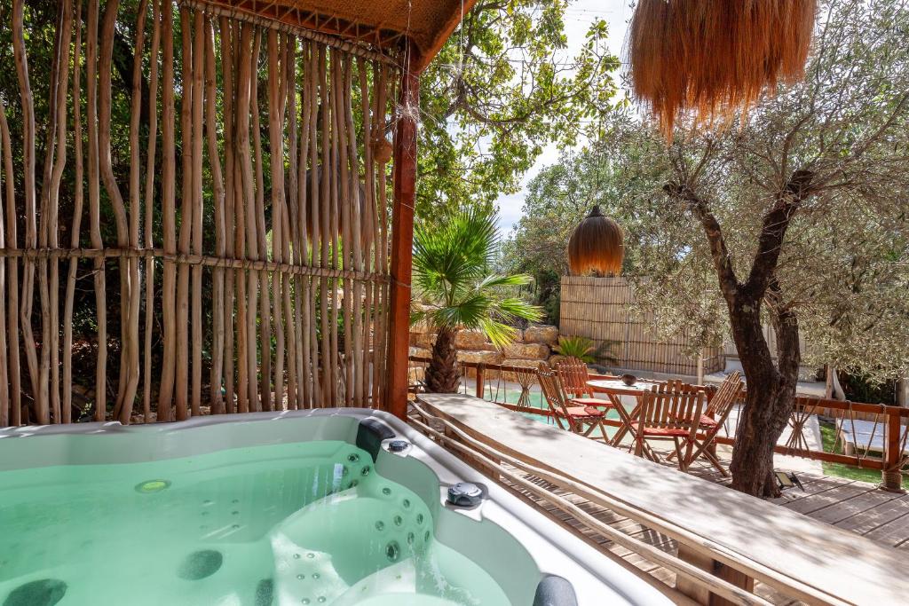 a jacuzzi tub on a porch with a patio at Bali House in Peypin