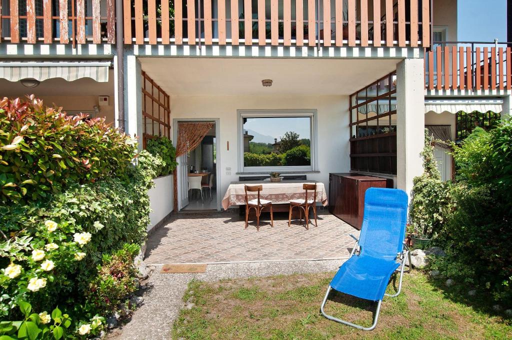 a patio with a table and a blue chair at Casa vacanze al Boschetto in Masina