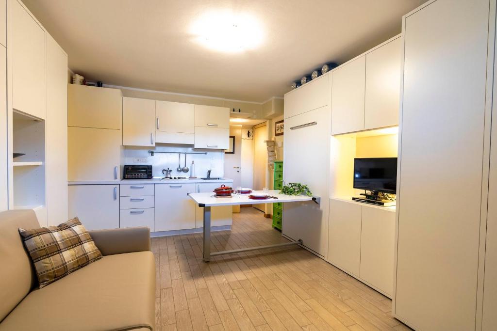 a kitchen with white cabinets and a table in a room at Modern Practical Studio In Sauze in Sauze d'Oulx