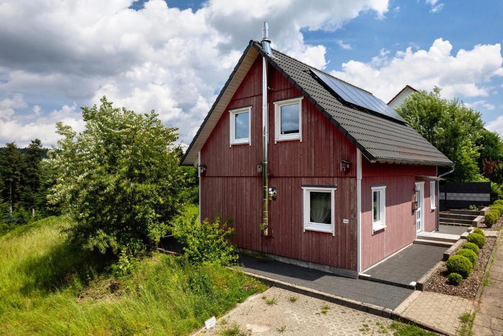 a red house with a black roof at Ferienhaus Waldfee in Reutin