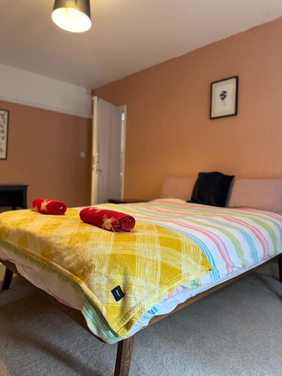 a bedroom with a bed with red pillows on it at Dickens HideAway in Hollington