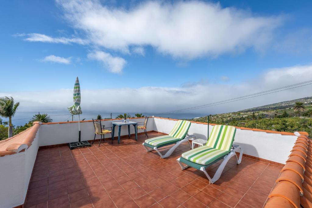 a patio with two chairs and a table on a roof at Casa Isabel in Tijarafe